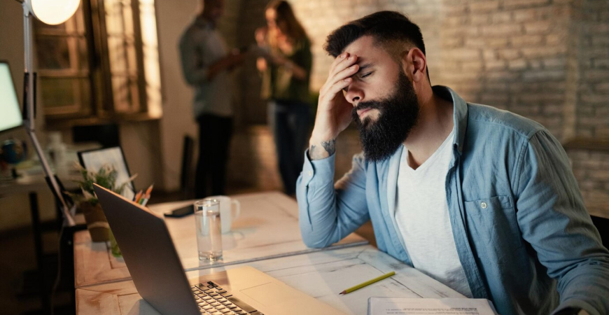 Empreendedor lidando com os desafios econômicos na gestão empresarial, demonstrando preocupação em seu ambiente de trabalho.